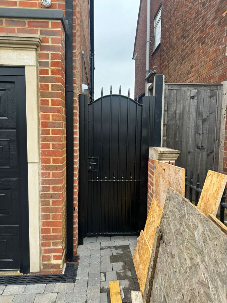 Arched-top gate with vertical slats and decorative spear tops