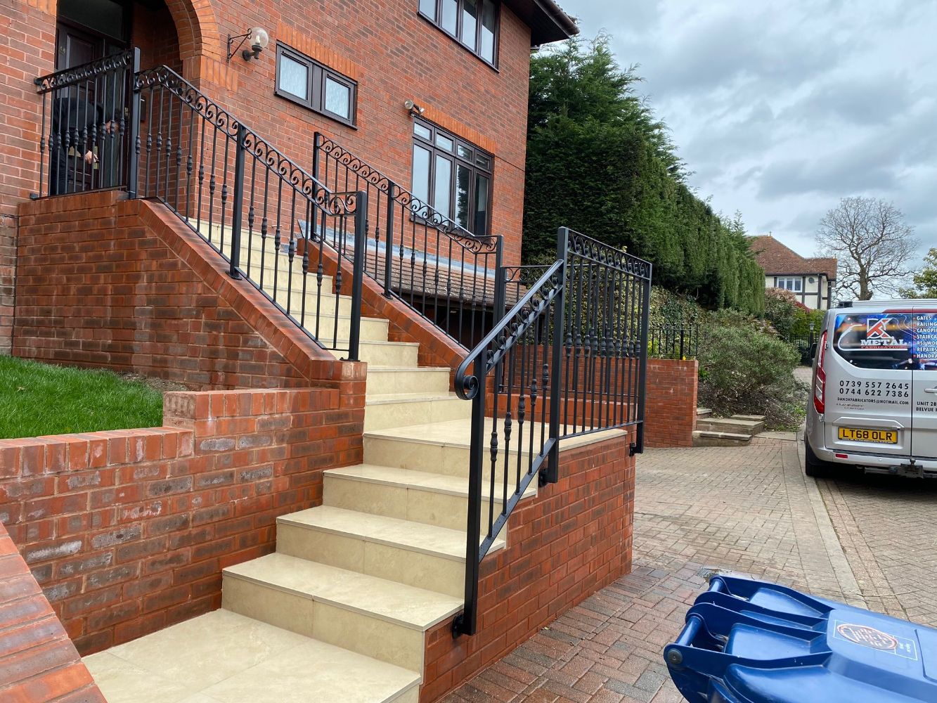 Elegant residential entrance with ornate wrought iron railings featuring decorative scrollwork
