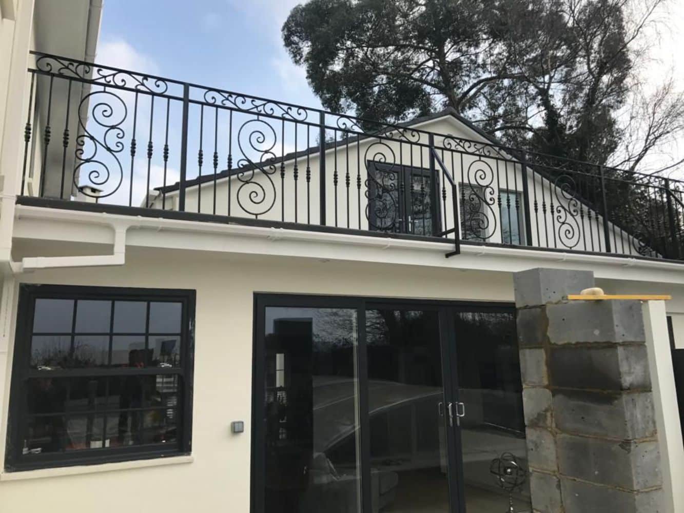 Elegant curved balcony with ornate wrought iron scrollwork railings